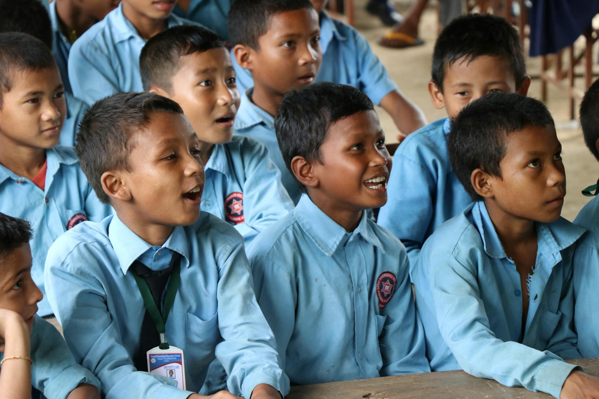 A group of boys in school uniforms engaging attentively in a classroom.