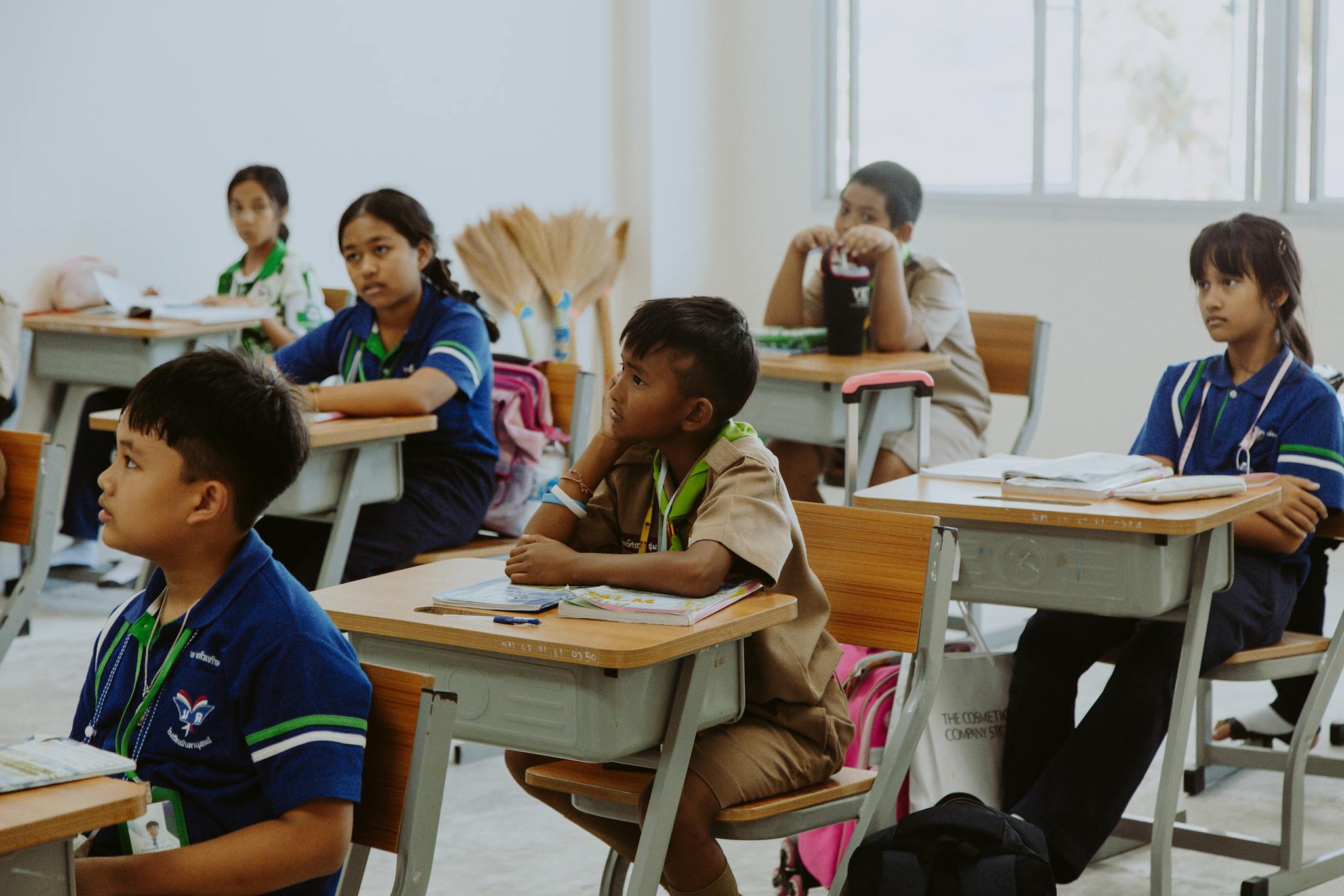 Children attentively listening in a classroom setting, focused on learning and education.